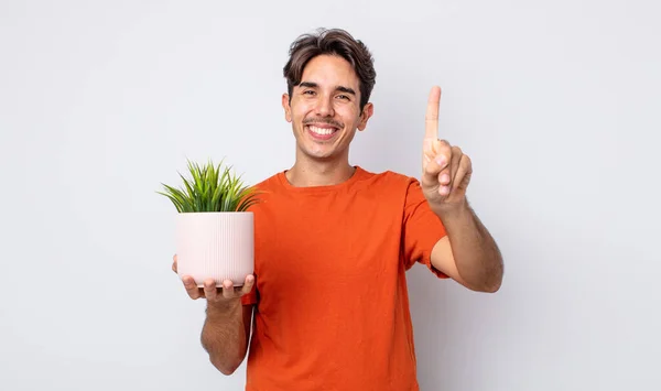 Jeune Homme Hispanique Souriant Regardant Amical Montrant Numéro Concept Plante — Photo