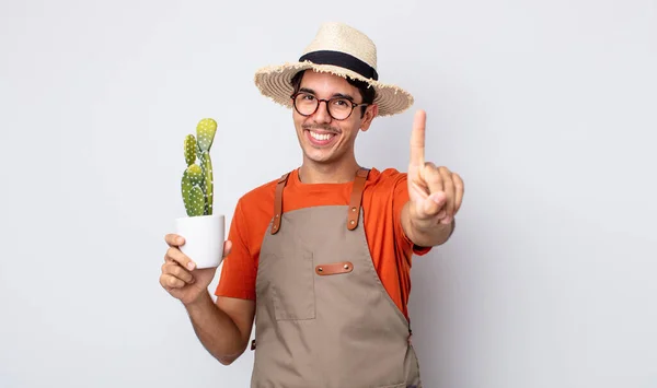 Joven Hispano Sonriendo Orgullosa Confiadamente Haciendo Número Uno Jardinero Con —  Fotos de Stock