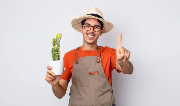 Young Hispanic Man Smiling Looking Friendly Showing Number One Gardener — Stock Photo, Image