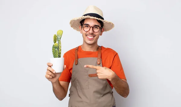 Young Hispanic Man Smiling Cheerfully Feeling Happy Pointing Side Gardener — Stock Photo, Image