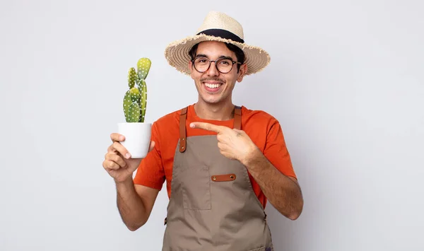 Young Hispanic Man Looking Excited Surprised Pointing Side Gardener Cactus — Stock Photo, Image
