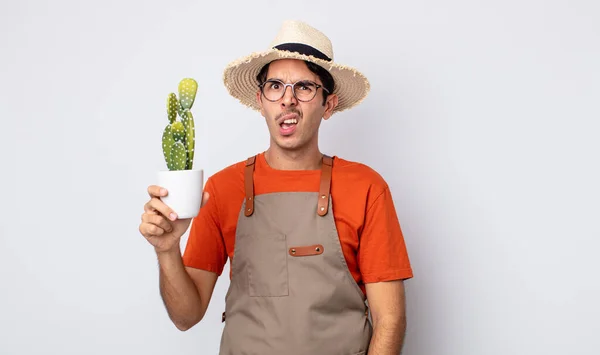 Young Hispanic Man Feeling Puzzled Confused Gardener Cactus Concept — Stock Photo, Image