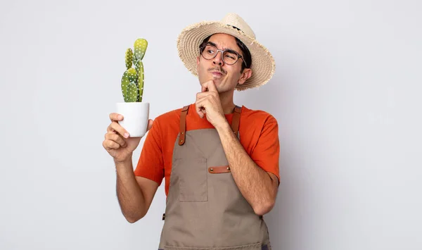 Young Hispanic Man Thinking Feeling Doubtful Confused Gardener Cactus Concept — Stock Photo, Image