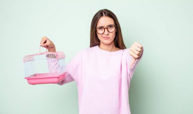 Genç ve güzel bir kadın kendini kötü hissediyor, baş parmağını kaldırıyor. evcil hayvan kafesi