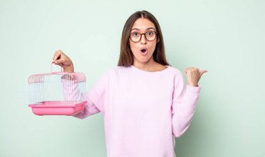 İnançsızlığa şaşırmış genç, güzel bir kadın. evcil hayvan kafesi