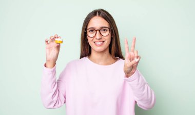 Genç, güzel bir bayan gülümsüyor ve iki numarayı gösteriyor. kontak lensler konsepti