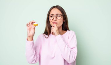 Genç, güzel bir kadın düşünüyor, kuşkulu ve şaşkın hissediyor. kontak lensler konsepti