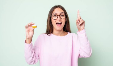 Genç ve güzel bir kadın bir fikri fark ettikten sonra mutlu ve heyecanlı bir dahi gibi hissediyor. kontak lensler konsepti