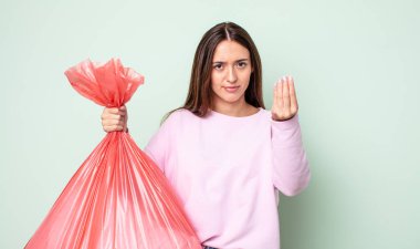 Genç ve güzel bir kadın kapiş ya da para hareketi yapıyor, sana ödemeni söylüyor. çöp konsepti