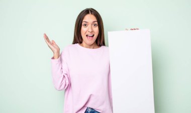 Genç ve güzel bir kadın inanılmaz bir şey karşısında kendini mutlu ve şaşkın hissediyor. boş tuval kavramı