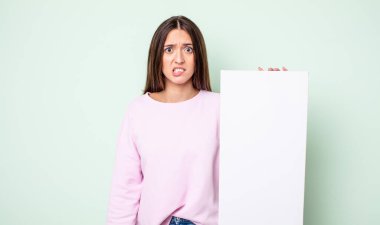 Genç, güzel bir kadın kafası karışmış ve şaşkın görünüyor. boş tuval kavramı