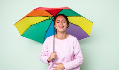 Genç ve güzel bir kadın komik bir şakaya yüksek sesle gülüyor. şemsiye kavramı