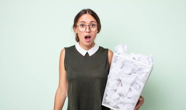 Genç ve güzel bir kadın çok şaşırmış ya da şaşkın görünüyor. kağıt toplar çöp konsepti