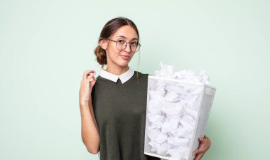 Genç ve güzel bir kadın kibirli, başarılı, pozitif ve gururlu görünüyor. kağıt toplar çöp konsepti