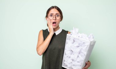 Genç ve güzel bir kadın şok olmuş ve korkmuş hissediyor. kağıt toplar çöp konsepti