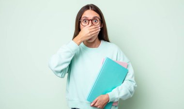 Genç ve güzel bir kadın şok olmuş bir şekilde elleriyle ağzını kapatıyor. üniversite öğrencisi.