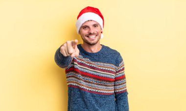 Genç ve yakışıklı bir adam kamerayı işaret ederek seni seçiyor. Noel konsepti