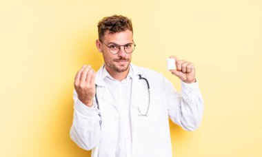 Genç yakışıklı adam kapiş ya da para hareketi yapıyor, sana ödemeni söylüyor. Hekim hapları şişesi konsepti