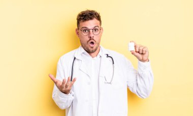 Genç yakışıklı adam, inanılmaz bir sürprizle şaşkına dönmüş ve hayrete düşmüştü. Hekim hapları şişesi konsepti