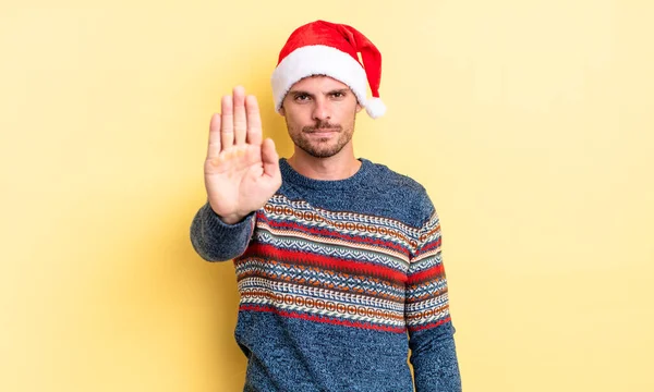 ヤングハンサムな男が真剣に手の平を開いてジェスチャーを止める クリスマスのコンセプト — ストック写真