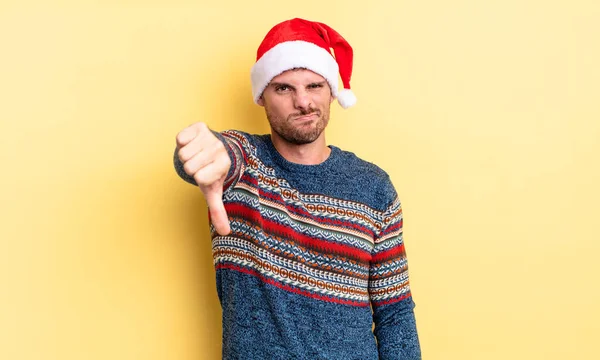 若いハンサムな男は 親指を下に示す クロス感 クリスマスのコンセプト — ストック写真