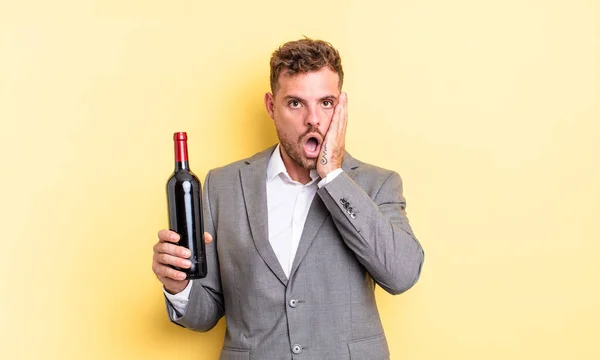 Jovem Homem Bonito Sentindo Chocado Assustado Garrafa Vinho Conceito — Fotografia de Stock