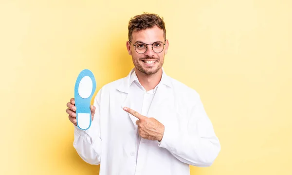 Joven Hombre Guapo Sonriendo Alegremente Sintiéndose Feliz Señalando Hacia Lado —  Fotos de Stock