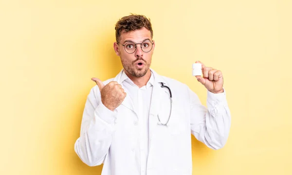 Young Handsome Man Looking Astonished Disbelief Physician Pills Bottle Concept — Stock Photo, Image