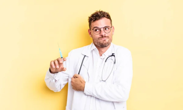 Young Handsome Man Shrugging Feeling Confused Uncertain Physician Syringe Concept — Stock Photo, Image