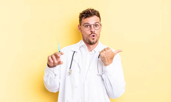 Young Handsome Man Looking Astonished Disbelief Physician Syringe Concept — Stock Photo, Image