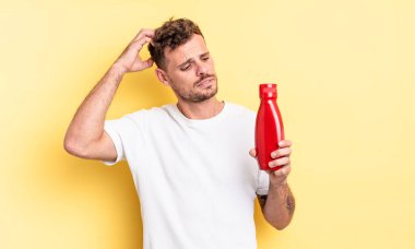 Genç yakışıklı adam mutlu bir şekilde gülümsüyor ve hayal kuruyor ya da şüphe ediyor. Ketçap konsepti