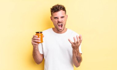 Genç ve yakışıklı bir adam sinirli, sinirli ve sinirli görünüyor. şeftali reçeli konsepti