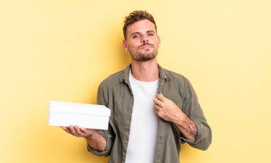 Genç yakışıklı adam kibirli, başarılı, pozitif ve gururlu görünüyor. beyaz kutu kavramı