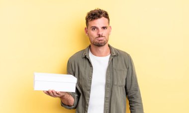 Genç ve yakışıklı bir adam üzgün ve mızmızlanıyor. Mutsuz bir bakışı var ve ağlıyor. beyaz kutu kavramı