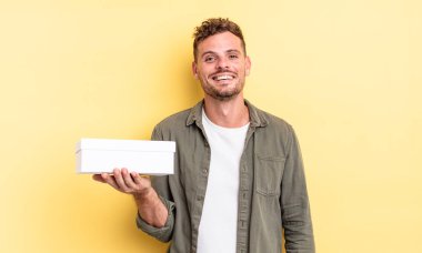 Genç yakışıklı adam mutlu ve hoş bir şekilde şaşırmış görünüyor. beyaz kutu kavramı