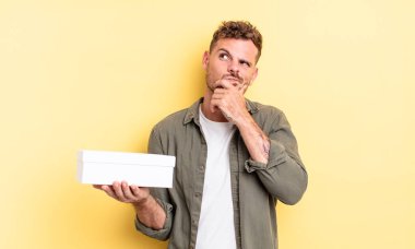 Genç yakışıklı düşünen, kuşkulu ve kafası karışık bir adam. beyaz kutu kavramı