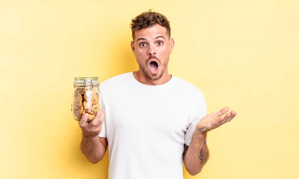 Joven Guapo Hombre Sentirse Muy Sorprendido Sorprendido Galletas Botella Concepto — Foto de Stock