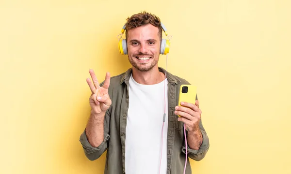 Jonge Knappe Man Glimlachend Zoek Vriendelijk Met Nummer Drie Koptelefoon — Stockfoto