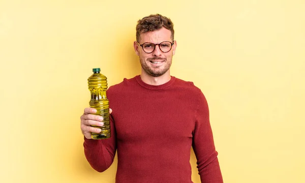 Der Junge Gutaussehende Mann Sah Verwirrt Und Verwirrt Aus Olivenölkonzept — Stockfoto
