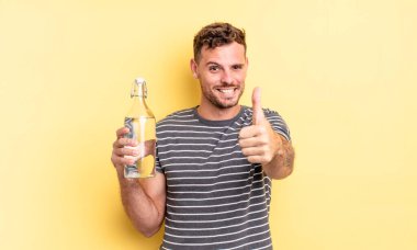 Genç ve yakışıklı bir adam gururlu, olumlu gülümsüyor. su kavramı