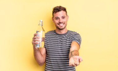 Genç ve yakışıklı bir adam arkadaşça gülümsüyor ve bir konsept sunuyor. su kavramı