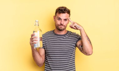 Genç yakışıklı adam kafası karışık ve şaşkın hissediyor, deli olduğunu gösteriyor. su kavramı