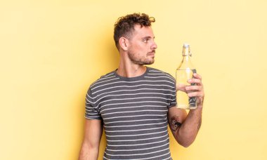 Profilde genç yakışıklı bir adam hayal kuruyor, hayal kuruyor ya da hayal kuruyor. su kavramı