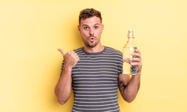 İnanamadığı için şaşırmış genç ve yakışıklı bir adam. su kavramı