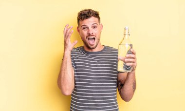 Genç yakışıklı adam ellerini havaya kaldırarak çığlık atıyor. su kavramı