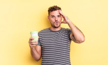 Genç yakışıklı adam mutlu, şaşkın ve şaşırmış görünüyor.