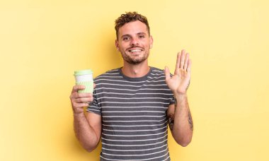 Genç yakışıklı adam mutlu bir şekilde gülümsüyor, el sallıyor, hoş geldin diyor ve seni selamlıyor.