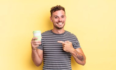 Genç yakışıklı adam neşeyle gülümsüyor, mutlu hissediyor ve konsepti ortadan kaldırıyor.