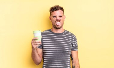 Genç yakışıklı adam tiksinmiş ve sinirlenmiş hissediyor ve dilini dışarı çıkarıyor.