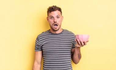 Genç yakışıklı adam çok şaşırmış ya da şaşırmış görünüyor.
